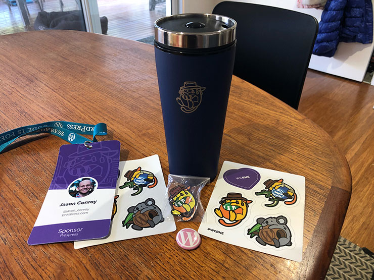 Stickers and cups: some of my swag from WordCamp Brisbane.